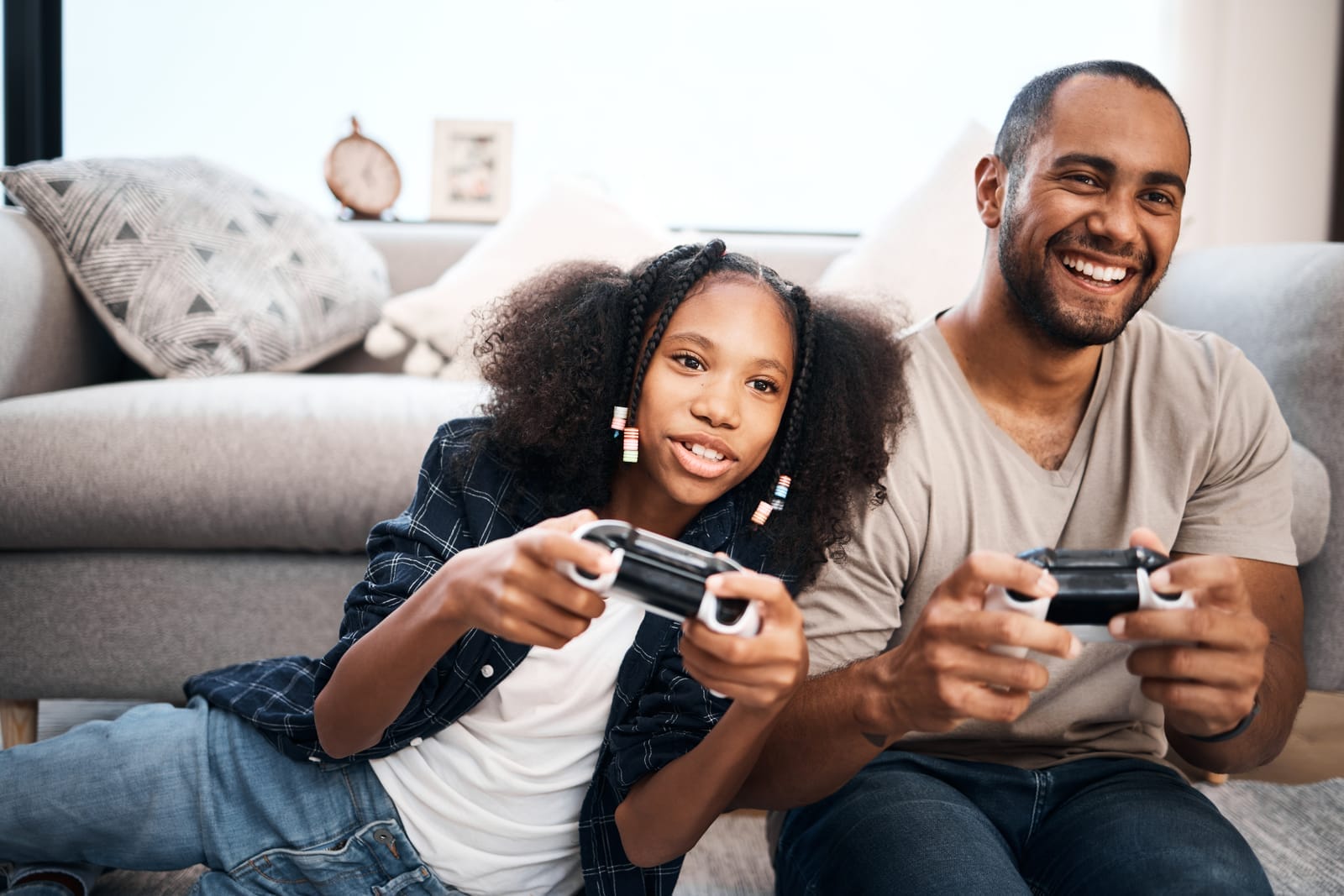 pai e filha adolescente jogando videogames juntos, representando o conceito de fazer as pazes com a filha