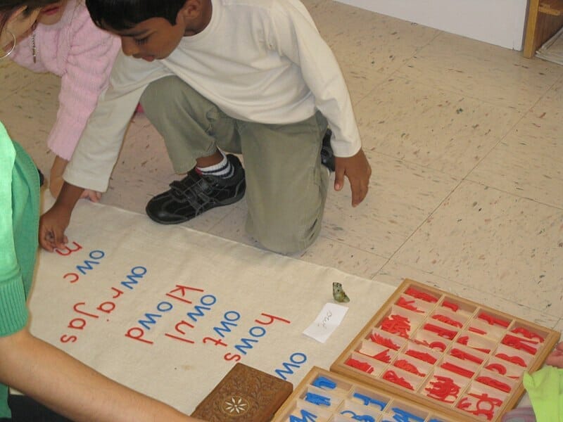 Alunos brincando com um alfabeto móvel em escola montessoriana