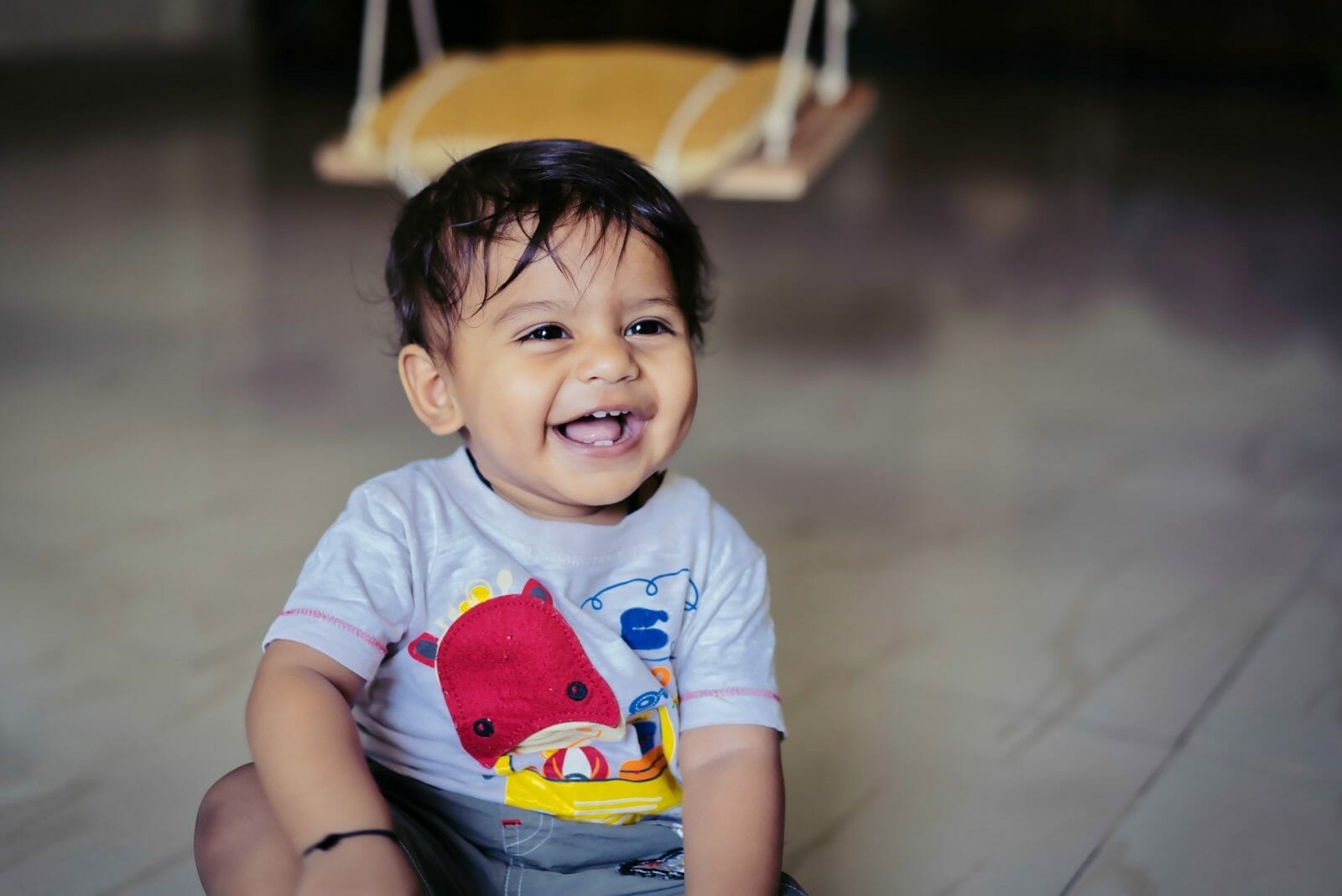 Bebê indiano sentado no chão e sorrindo