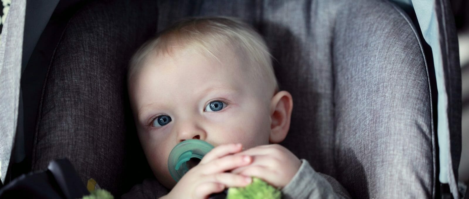 bebê sentado na cadeirinha no banco de trás do carro