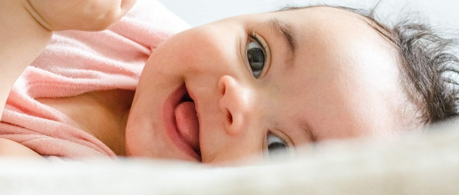 bebê sorrindo deitado na cama