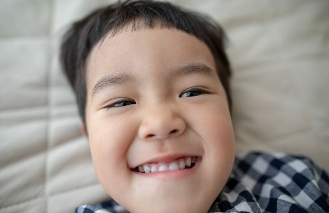 Bebê sorrindo com dentes brancos aparecendo