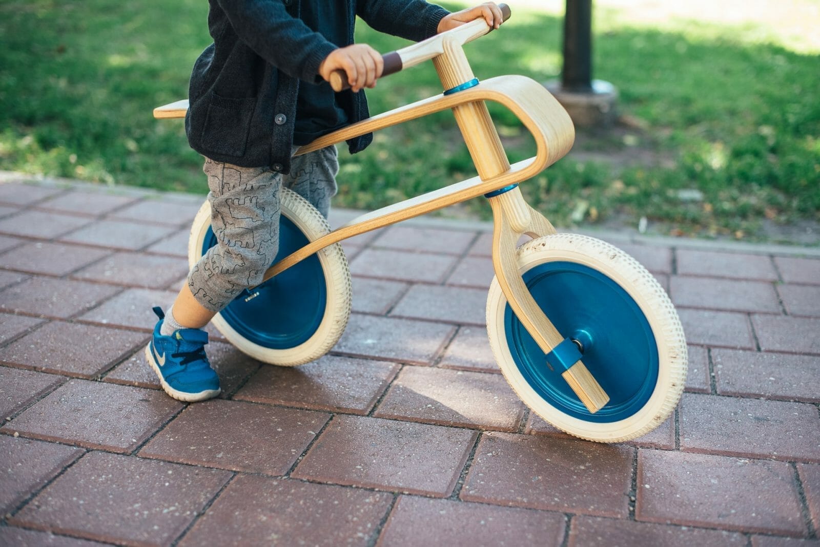 Criança pequena praticando com bicicleta de equilíbrio
