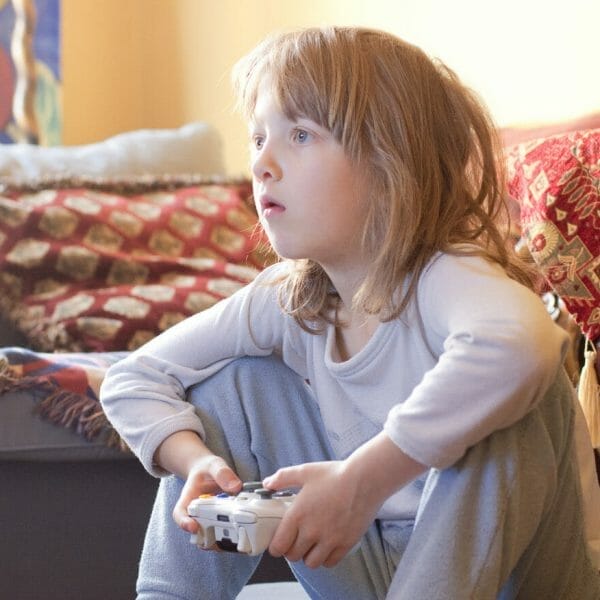 Criança concentrada jogando videogame