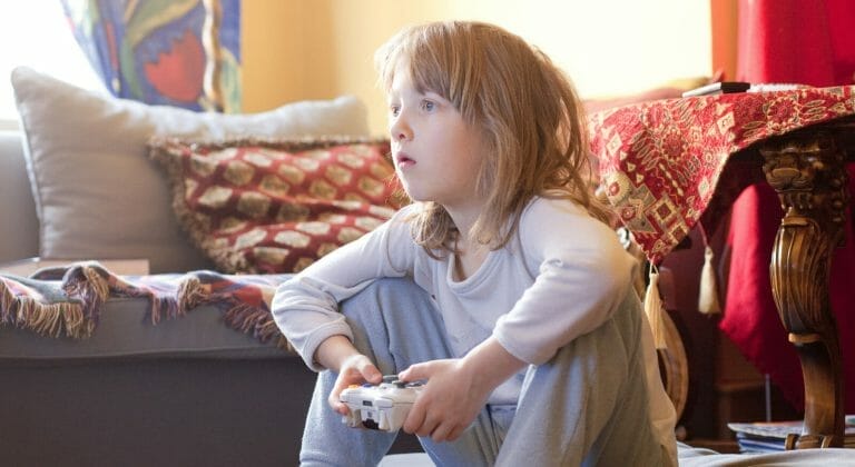 Criança concentrada jogando videogame