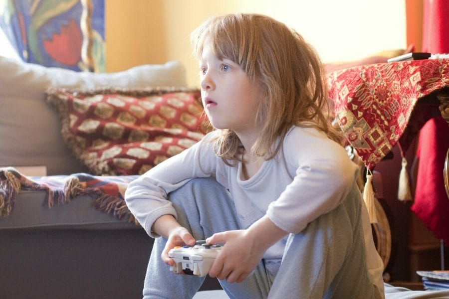 Criança concentrada jogando videogame