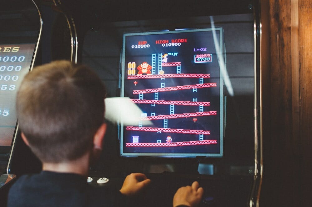 Criança jogando Champ Kong em um videogame antigo