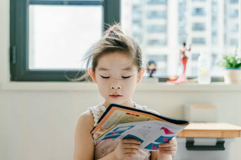 Criança lendo livro colorido