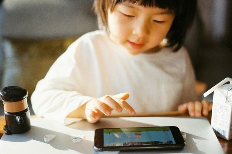tempo de tela na infância: criança usando celular para jogar