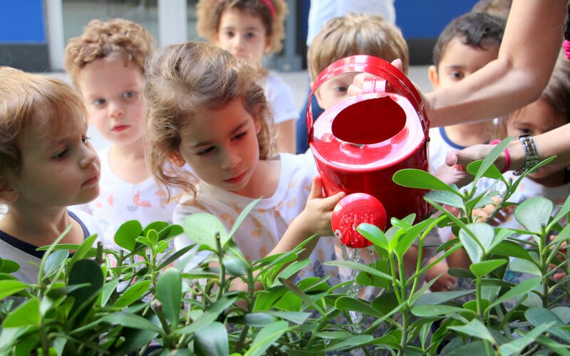 alunos da educação infantil regando horta na escola eliezer max