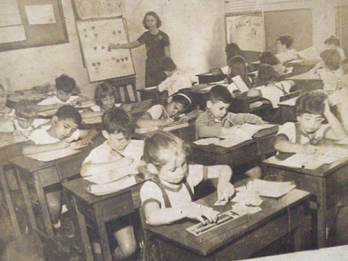 alunos sentados em mesas de escola, em aula em um dos colégios que se fundiu para dar origem ao eliezer max