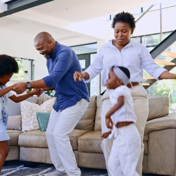 pai e mãe mostrando como é dançar como se ninguém estivesse vendo para um menino e uma menina na sala de estar