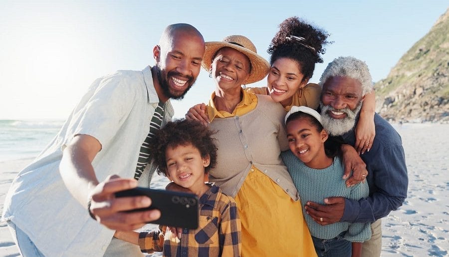 família tirando selfie em férias com crianças na praia