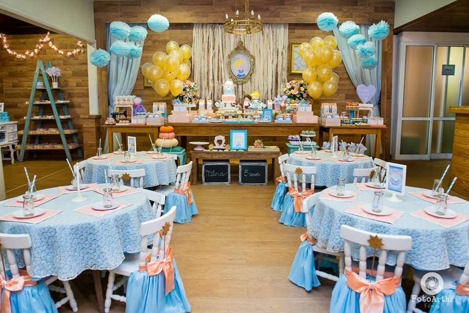 salão de festas da cinderela, com painel ao fundo e mesas com toalhas azul à frente