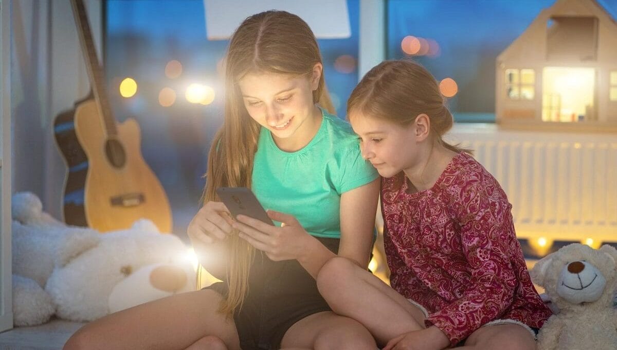 irmãs usando o celular, sentadas em cima da cama, com iluminação baixa, representando a geração tiktok