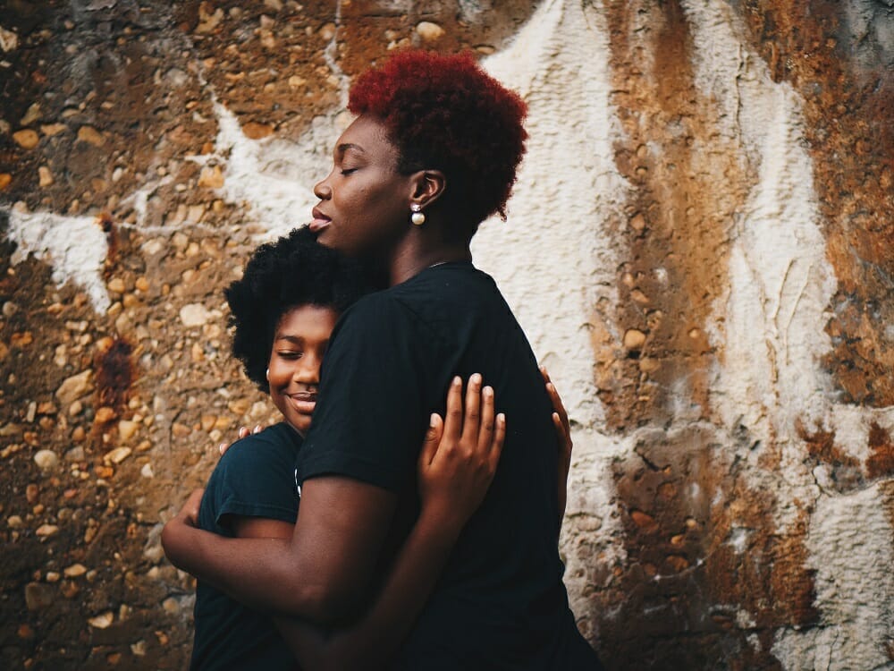 Mãe e filha se abraçando, demonstrando ser uma mãe mais amorosa