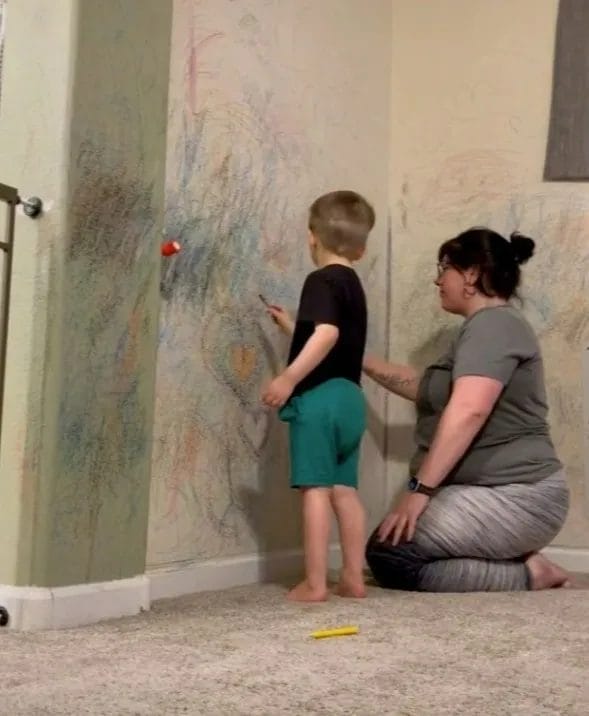 mae pintando parede com o filho