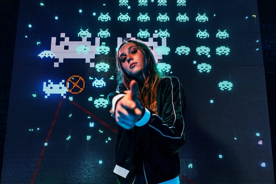 Mulher gamer na frente do jogo Space Invaders